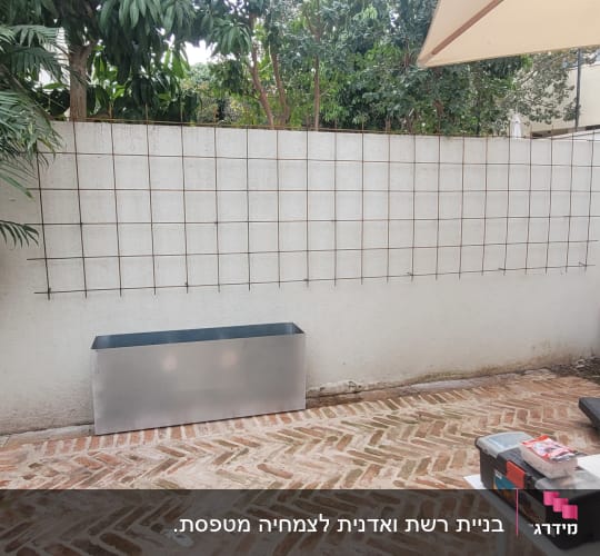 רשת סבכת מתכת ואדנית מתכת מותקנות על קיר בחצר בית